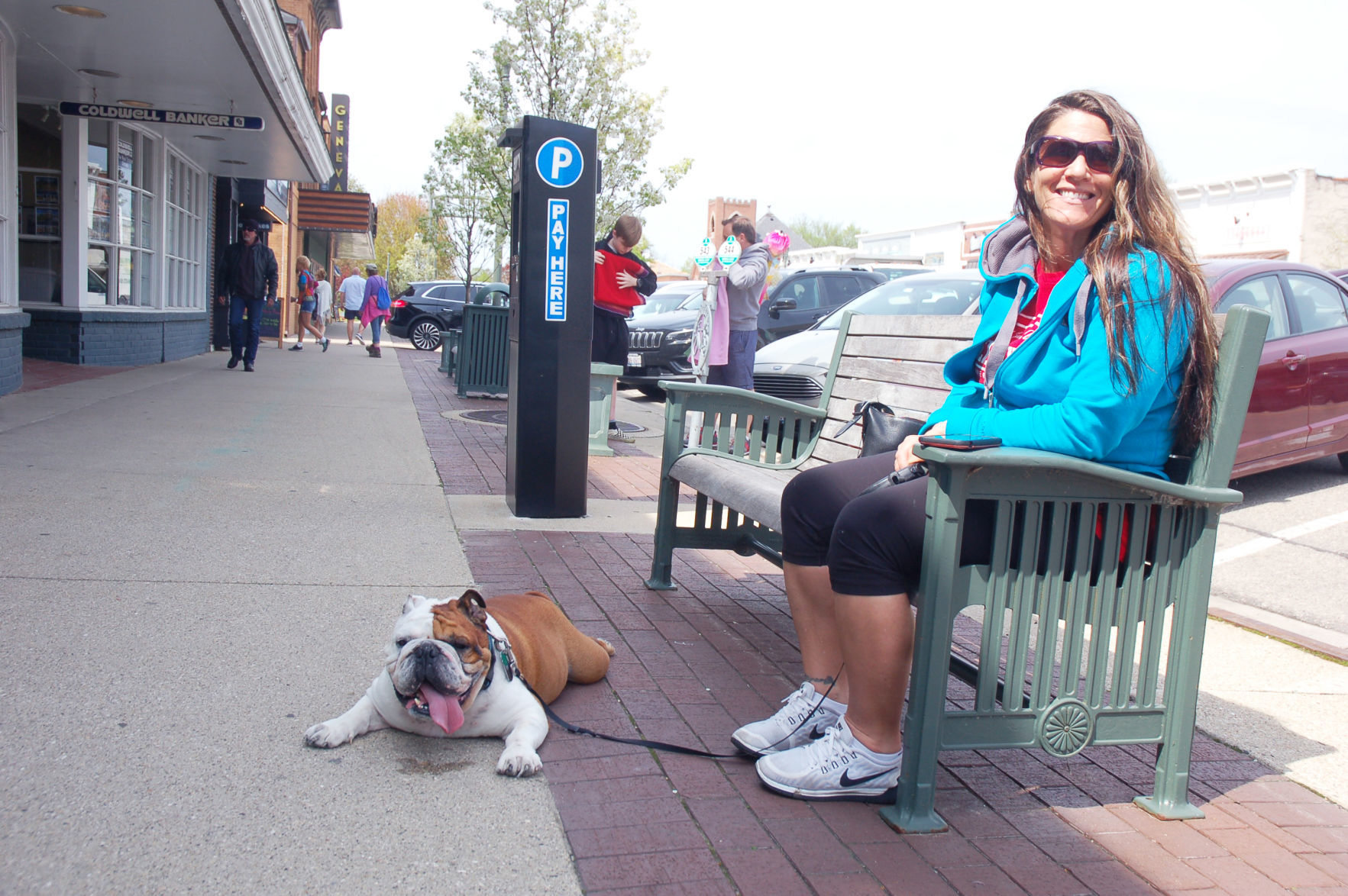 Woman relaxes on bench with her bulldog on Broad Street